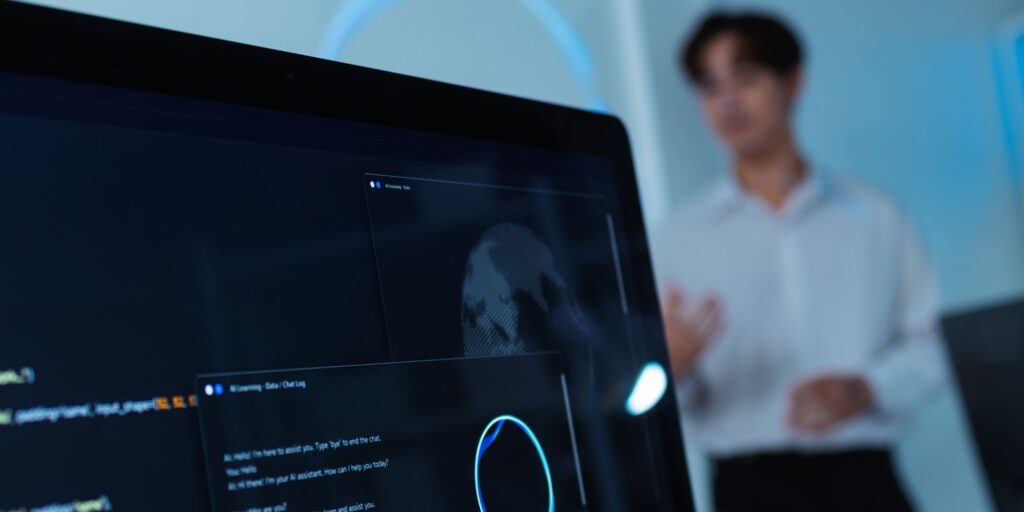 Ein Bildschirm mit AI Tools, im Hintergrund ein Mann in weißem Hemd